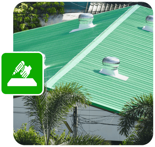 Green metal roof with ventilation turbines and lush greenery.