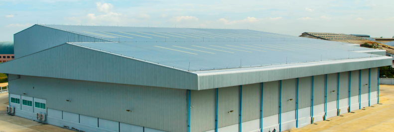 Large industrial warehouse with metal siding and sloped roof